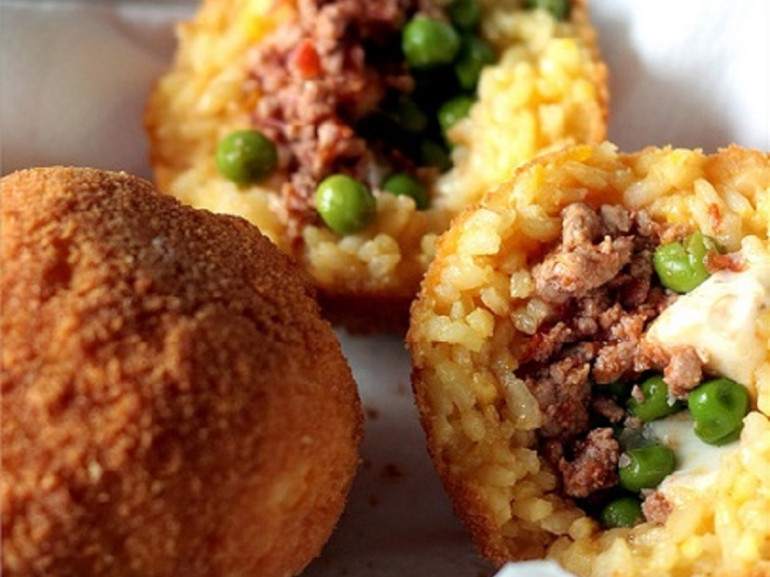 It's a ball or a cone of rice breaded and fried, generally stuffed with meat sauce, peas and cheese or diced ham and mozzarella. The name comes from the original form and the typical golden color, reminiscent of an orange, but it must be said that in eastern Sicily arancini more often have a conical shape. Green Guide Sicily